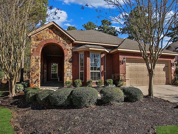 Stone and brick front elevation with a two-car garage.