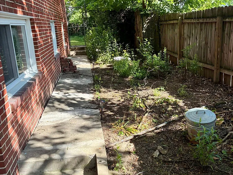 Native garden along side of house at foot of driveway. To the left is the entrance to the lower level.