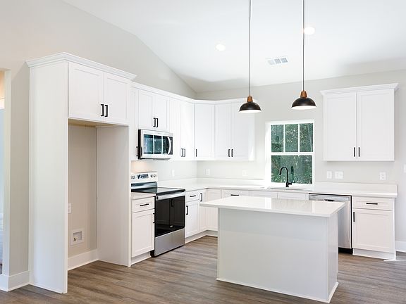Kitchen with new stainless appliances and large island (refrigerator now installed)