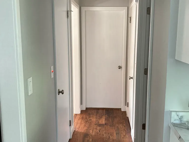 Main floor hallway from kitchen. Bathroom on right, closet on right, spare room straight ahead, access to basement first door on left and access to living room second entry on left