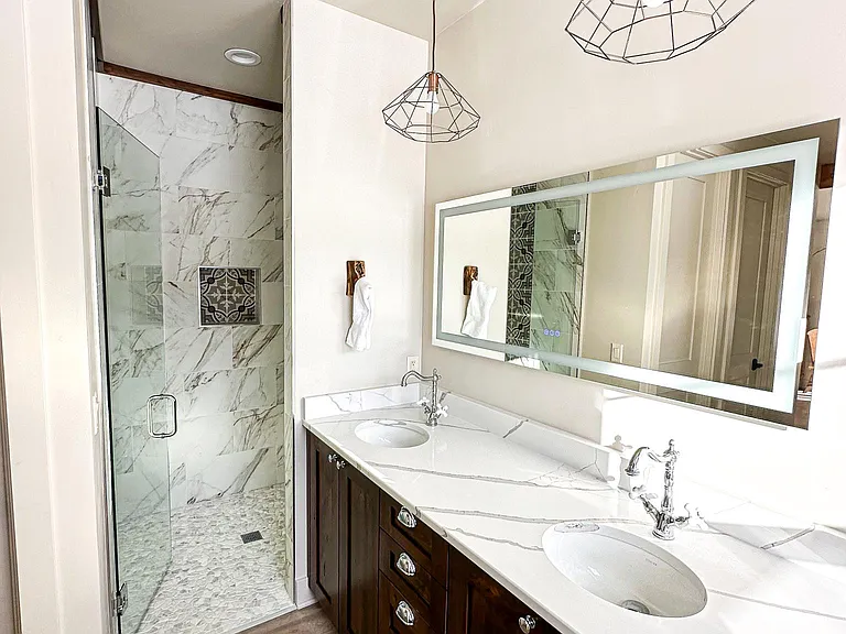 Lazy Bear ensuite bath with large, modern shower and double vanity. The mirror has adjustable surround lighting and can serve as a night light if you wish.