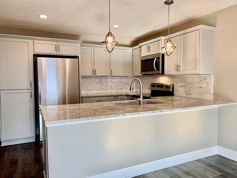 Large granite countertop that offers area for barstool seating