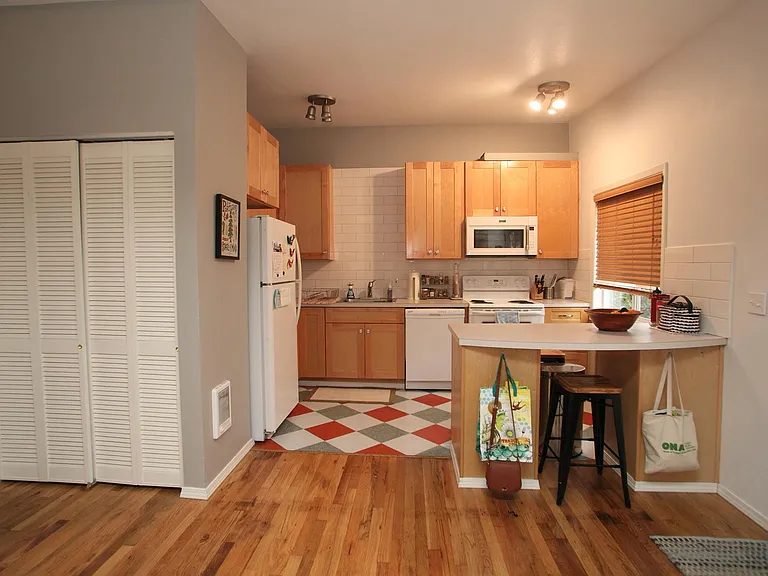 Kitchen with walls painted in light gray and newer tile backsplash.