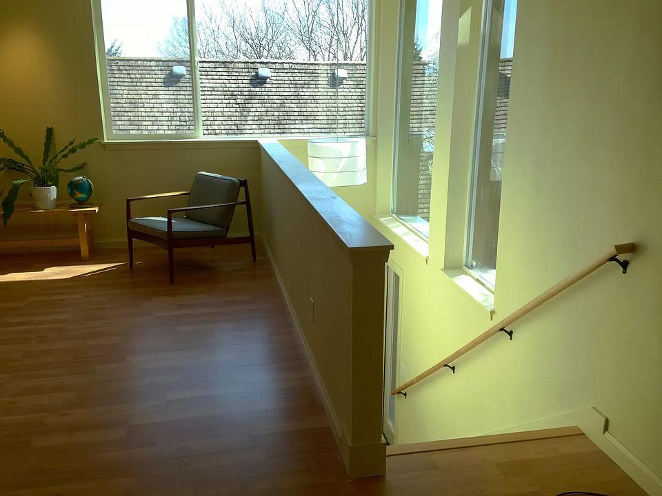 Living area (open to kitchen/dining) and stairs down to second bedroom or office.