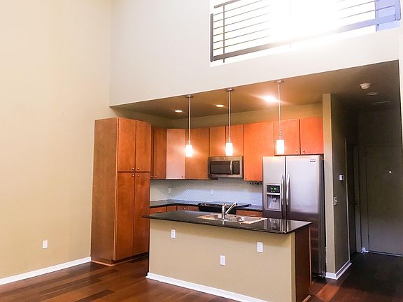 Kitchen with lots of storage. Stainless steel appliances. Large center island with breakfast bar and counters with granite countertops. Pendant lights. Vaulted ceilings.