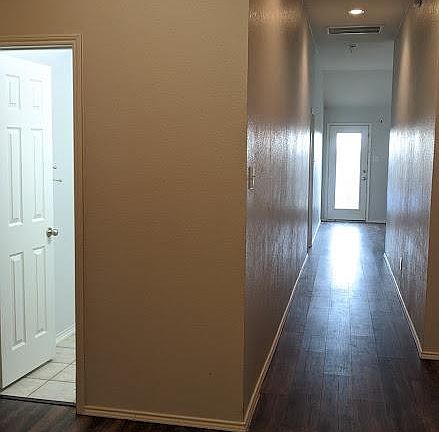 Entry and hallway with doorway to second bathroom on the left. Bedrooms #2 and 3 are to the left as well, with #4 located off of short hallway connecting garage, kitchen and bedroom #4