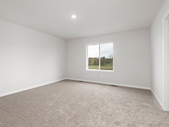 The master bedroom is spacious with a large window.