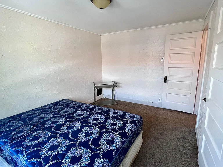 back bedroom (faces back porch and side driveway/alley)