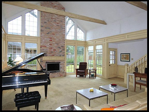 Incredible family room features cathedral ceiling, wood beams and windows across the back of the house.