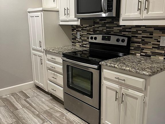 Kitchen with granite counter tops and stainless appliances.
