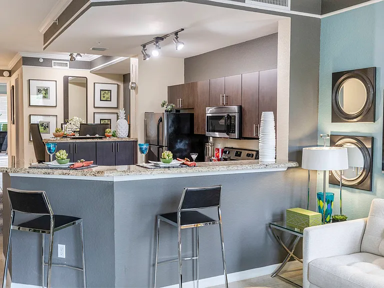 Spacious and well lit kitchen with wood flooring and stainless steel appliances