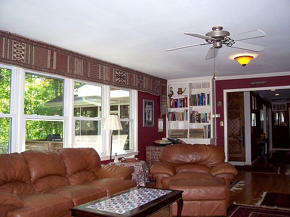 Living room with large windows, built-ins, and hardwood floor
