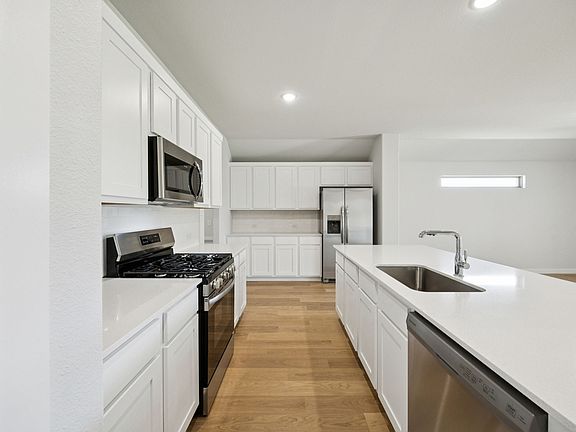 Kitchen in the Heisman home plan by Trophy Signature Homes - REPRESENTATIVE PHOTO