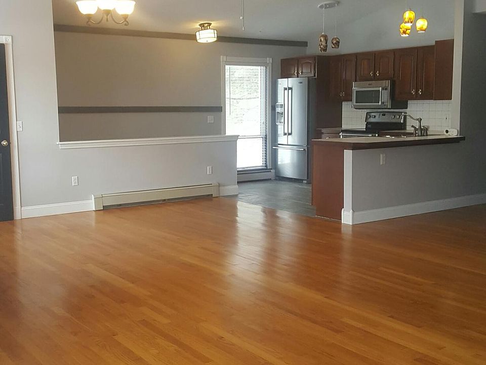 Living room view towards dining and kitchen. Hardwood floors. walk in closet off dining