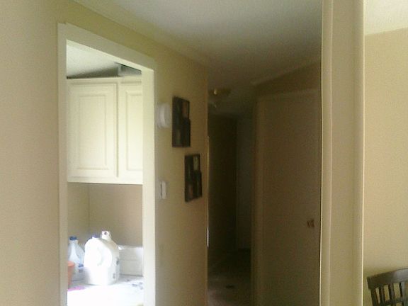 The front hall: laundry room on the left, two bedrooms on right, and bathroom