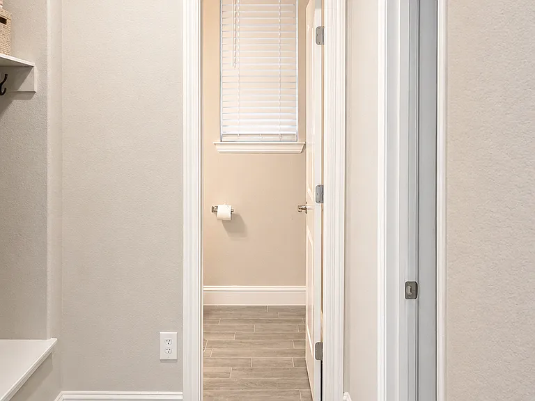 Mudroom hallway leading to half bath and office (bedroom 1)