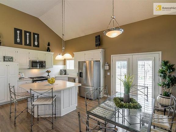 OPEN KITCHEN WITH NEWER APPLIANCES, CENTER ISLAND , BREAKFAST AREA AND FRENCH DOORS LEADING TO THE DECK