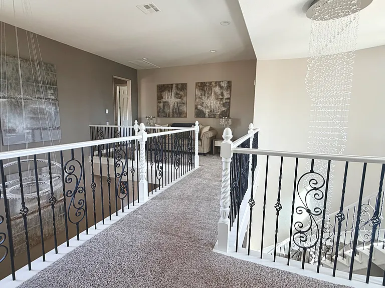 Walkway with reading nook, 13 foot crystal chandelier and large crystal ring chandelier, cast iron detailed banister