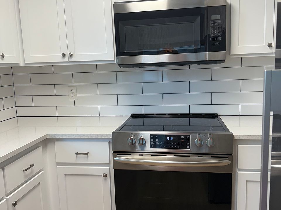 Glass top range and microwave with subway tile backsplash