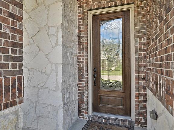 Beautiful front door greets you on this front porch. The house is brick and stone and has a full sprinkler system.