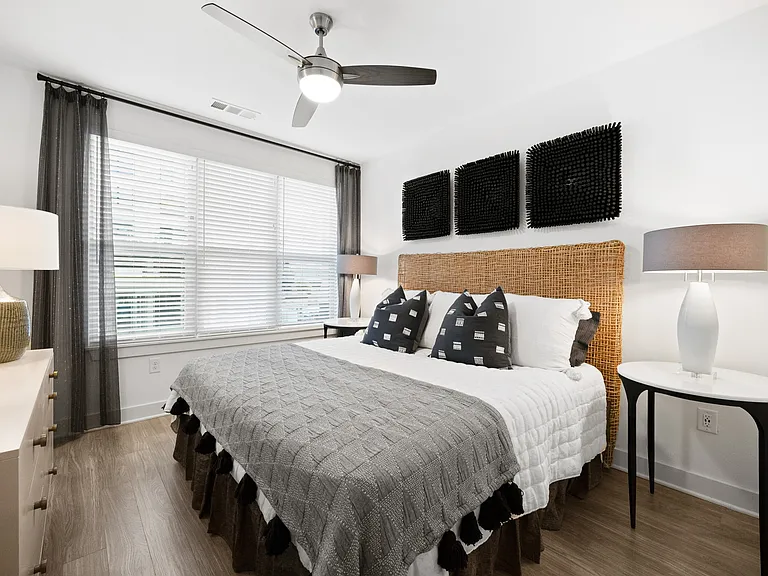 Spacious bedroom with oversized windows and ceiling fans