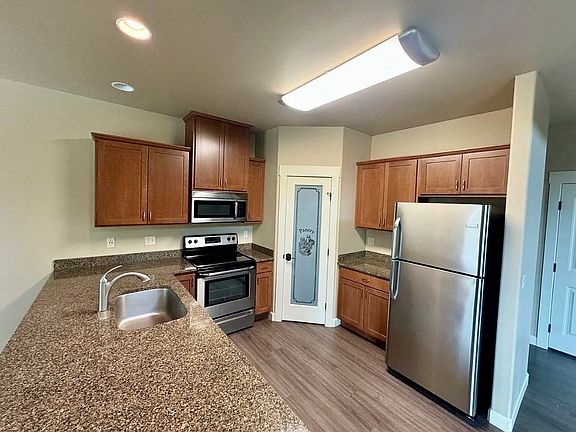granite countertop, walk-in pantry with stainless steel appliances