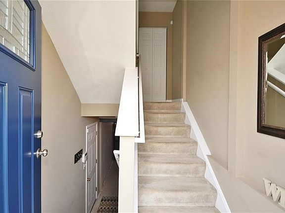 Welcome! Beautiful new front door.  Stairs lead to main level and lower level to oversized finished garage with door leading to backyard and patio.