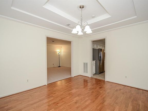 Formal dining features tray ceiling and gleaming hardwoods.