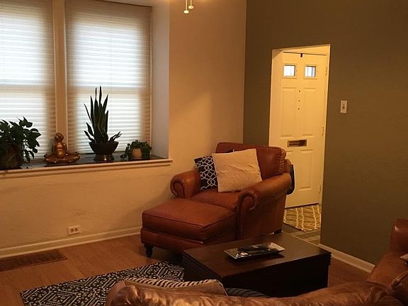 Living room features wood floors and tiled window countertop