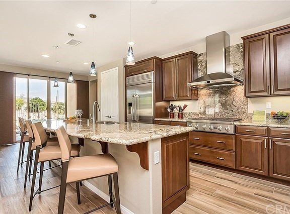 Kitchen features a built-in refrigerator, 6 burner stove top, double ovens, & more