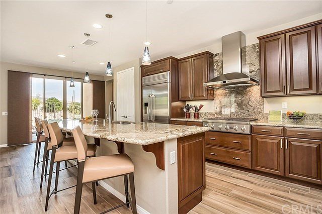 Kitchen features a built-in refrigerator, 6 burner stove top, double ovens, & more
