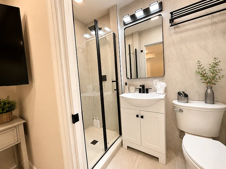 Modern shower in the Guest Suite bedroom - with updated tile, a walk-in glass enclosure, fresh towels, and a clean design for a comfortable Naples vacation rental experience.