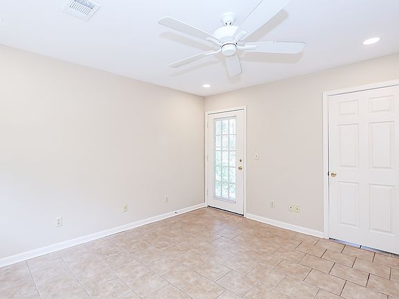 Living room showing door to deck (left) and door to bedroom (right).
