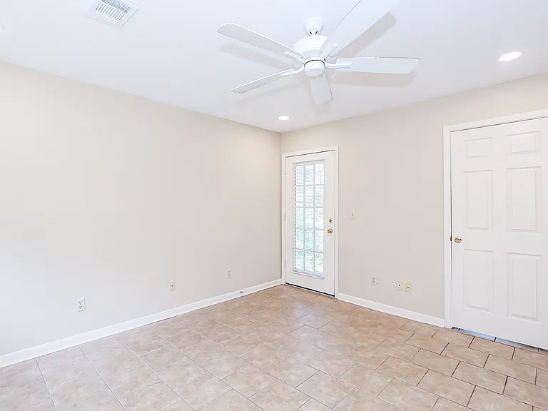 Living room showing door to deck (left) and door to bedroom (right).