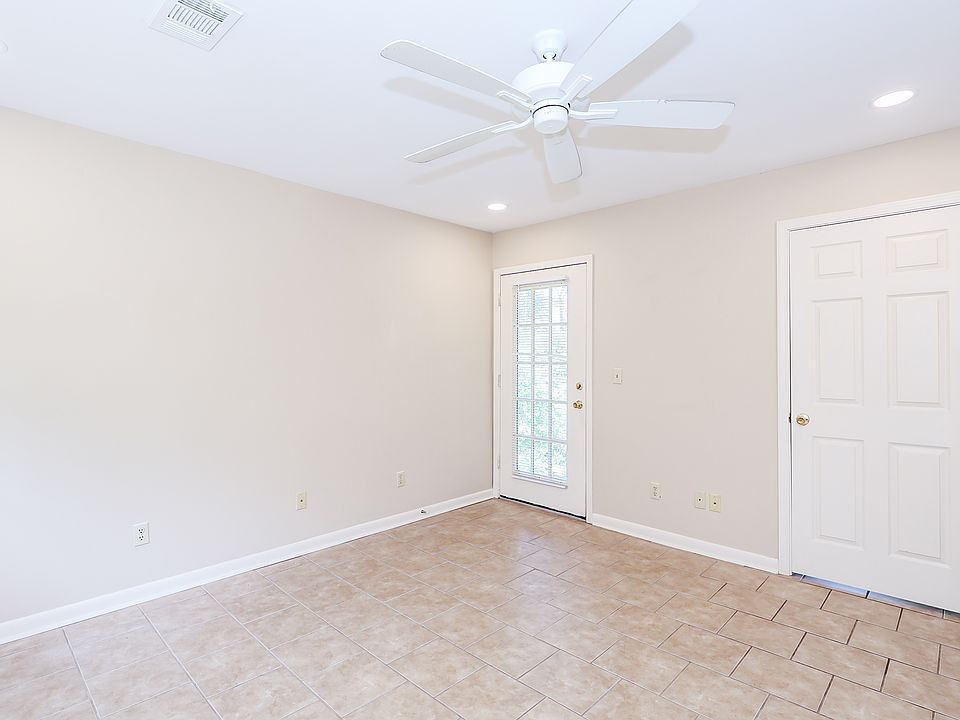 Living room showing door to deck (left) and door to bedroom (right).