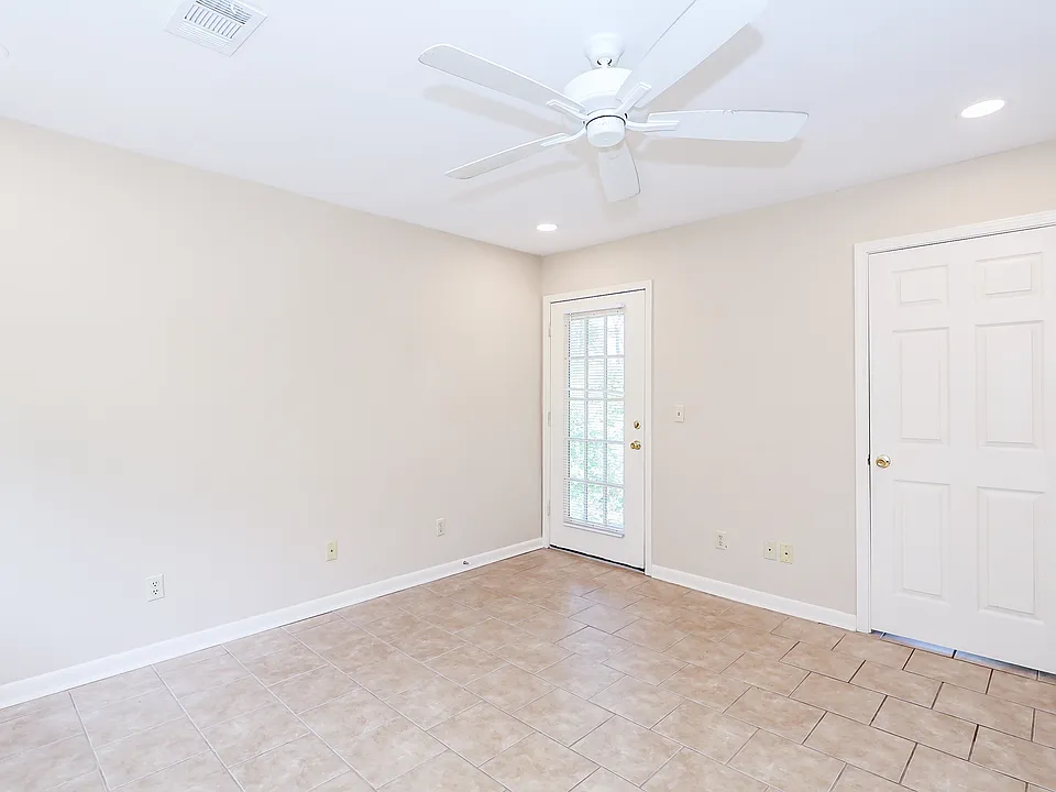 Living room showing door to deck (left) and door to bedroom (right).