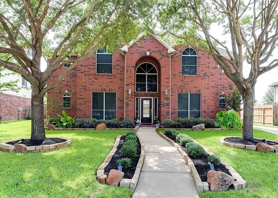Front view of home and lush landscaping with sprinkler system.