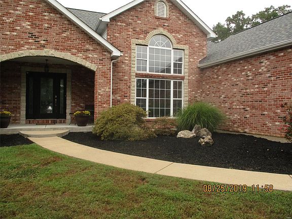 Closer look of the beautiful landscaping and  palladium windows at the entrance.