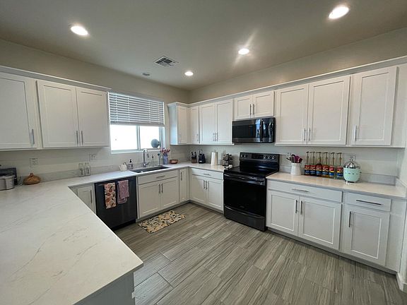 Kitchen with quartz countertops and black stainless steel appliances