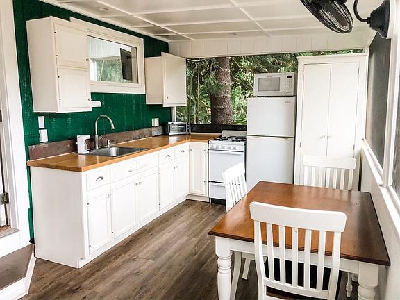 Kitchen including hidden stacked washer/dryer on the open air lana