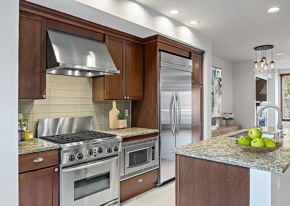 Gourmet kitchen with slab granite counters, glass tile backsplash, gas oven/range, and built-in refrigerator. Kitchen Aide appliance package. (second floor)