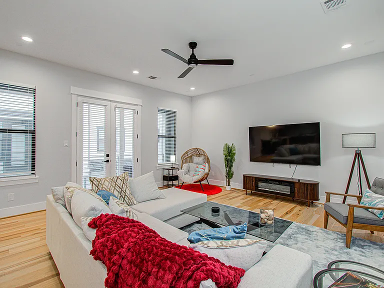 Spacious living room featuring a comfortable sectional sofa, 75" Smart TV, and cozy fireplace_the perfect place to relax, unwind, and enjoy time with family or friends.