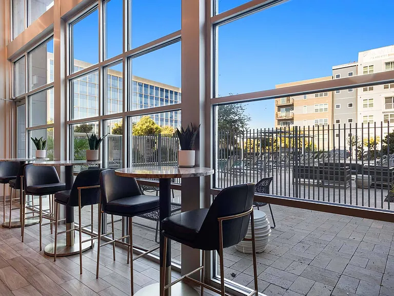 Sit back and enjoy the view from the bar stools by the window, overlooking the beautiful courtyard for a relaxing moment.