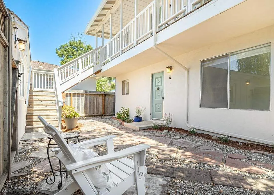 gated courtyard and stairs up to the unit with the balcony/deck