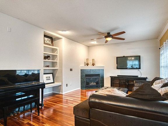 Kitchen opens to sunny dining room and living room with beautiful gas fireplace. Fans and a/c.