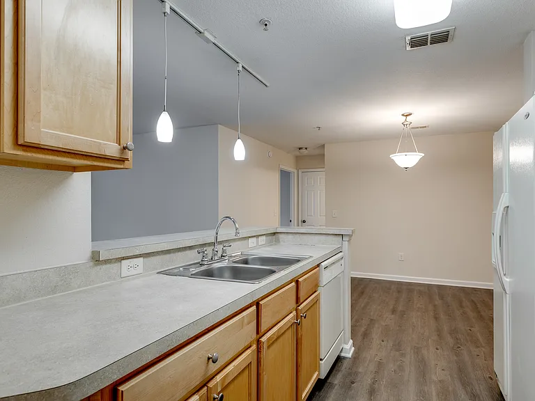 Modern kitchen with bar seating and pendant lighting.