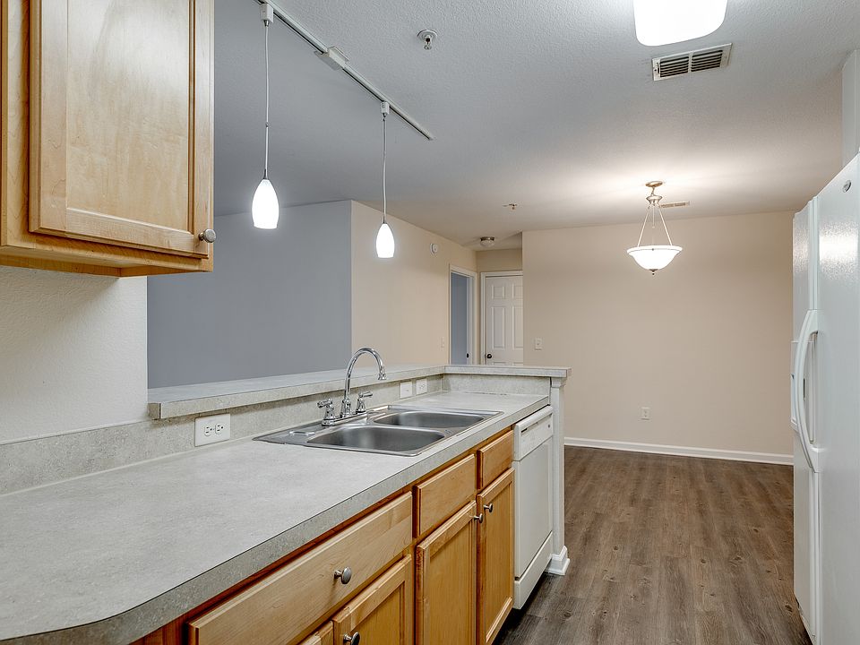 Modern kitchen with bar seating and pendant lighting.