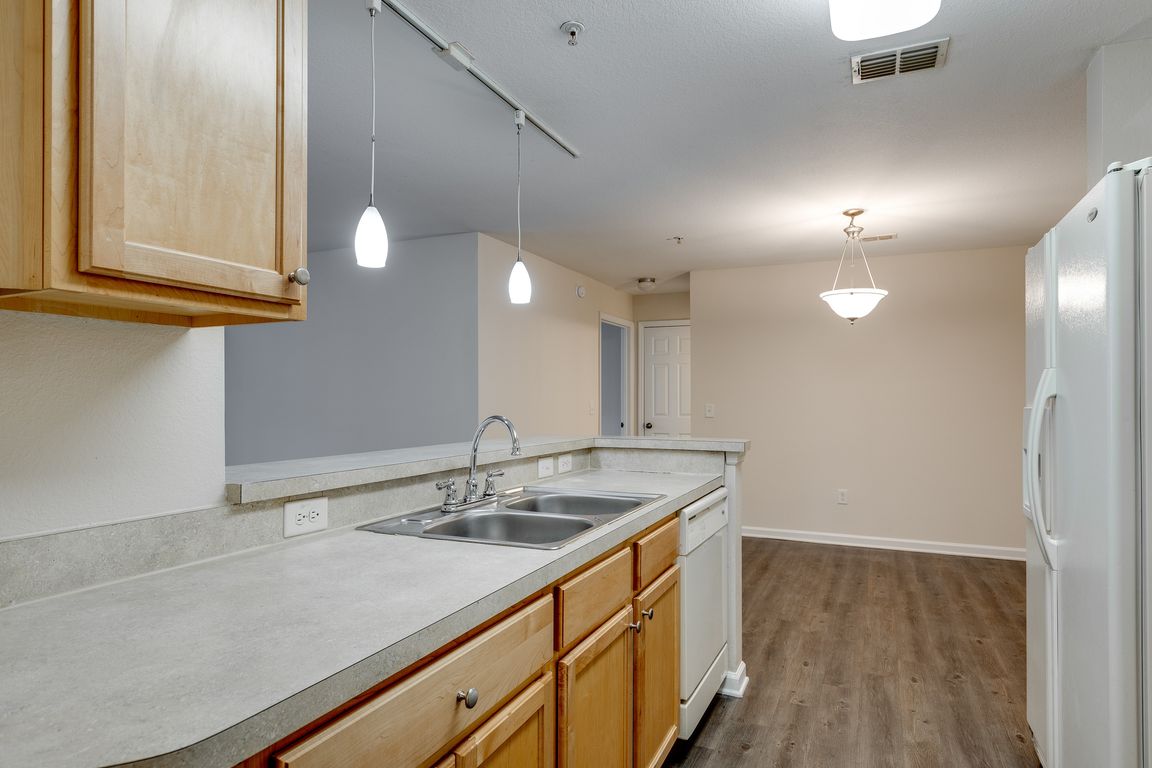 Modern kitchen with bar seating and pendant lighting.