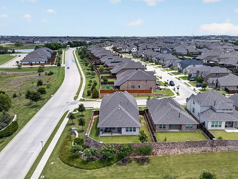 Expansive residential community featuring a variety of single-family homes with pitched roofs, individual backyards, and paved streets