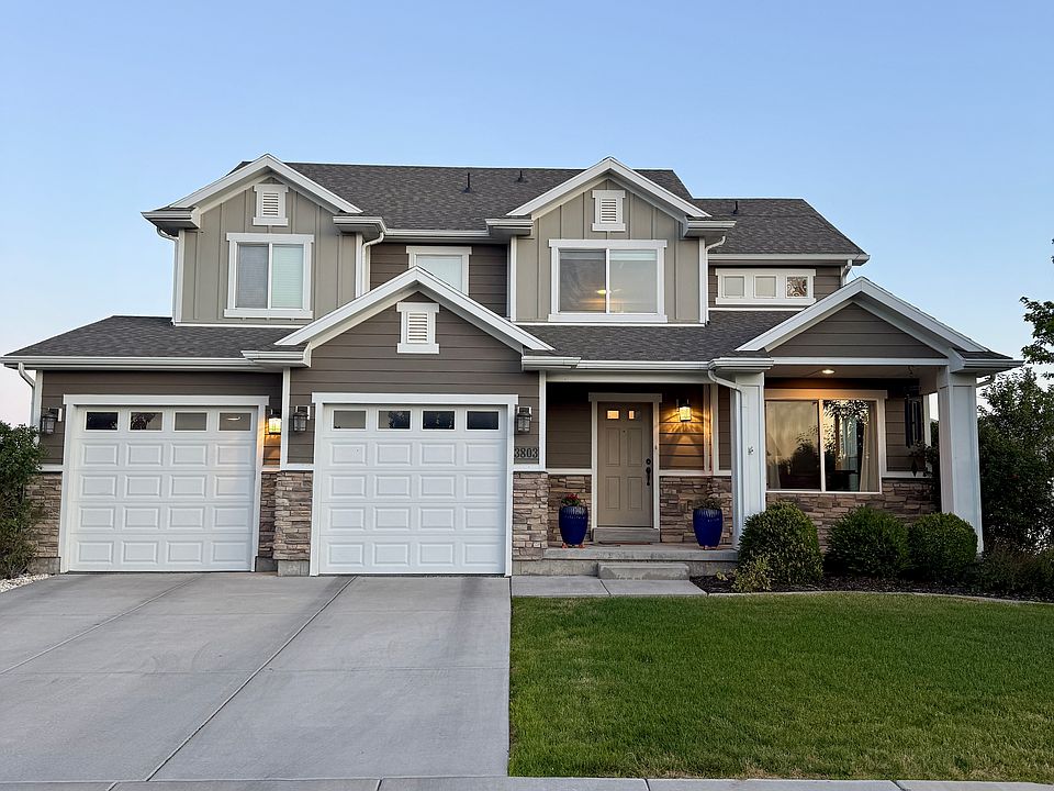 Front elevation with large front porch, auto exterior lighting and plenty of parking.